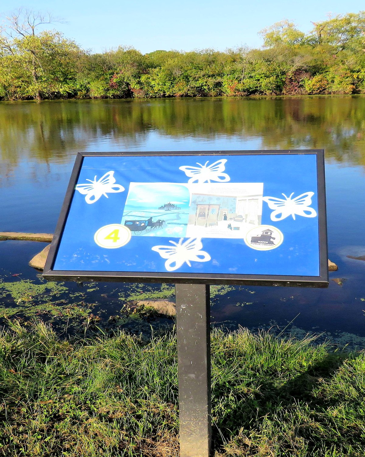 A StoryWalk display installed beside a lake